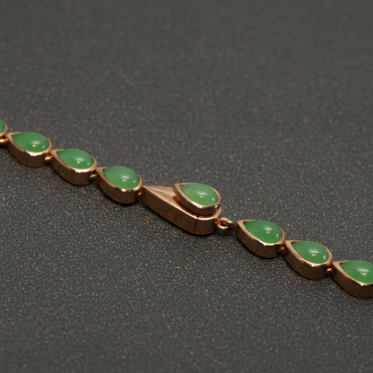 Makroansicht des handgefertigten, unsichtbar integrierten Kastenschlosses aus 750er Rotgold plattiertem 925 Silber, das sich nahtlos in die Reihe der gefassten Chrysoprastropfen einfügt.