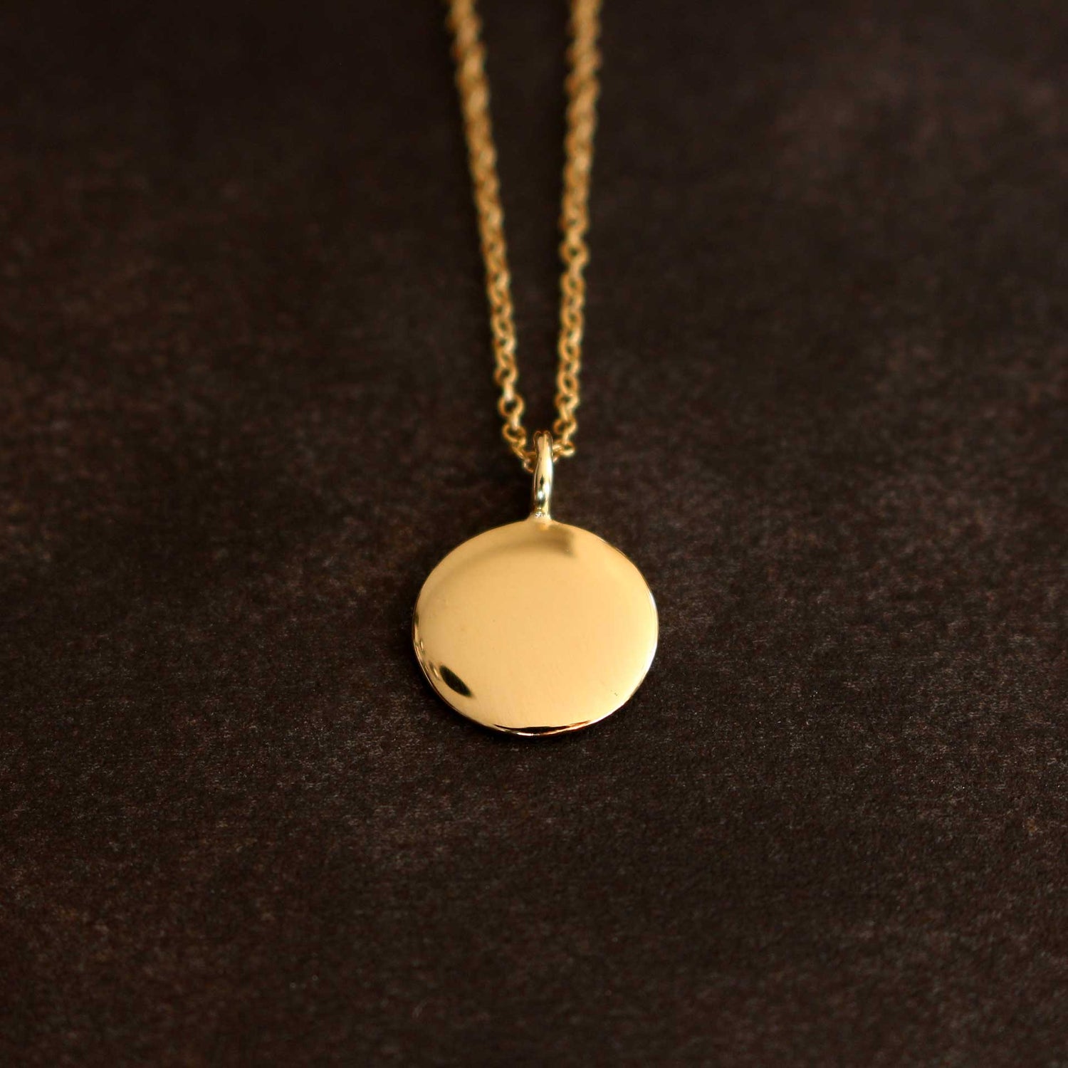 Handgefertigter runder Goldanhänger aus 18 Karat Gelbgold, Ø 12 mm. Zeitloses Design, hochwertige Verarbeitung. Perfekt für jeden Tag oder besondere Anlässe. Jetzt entdecken!
