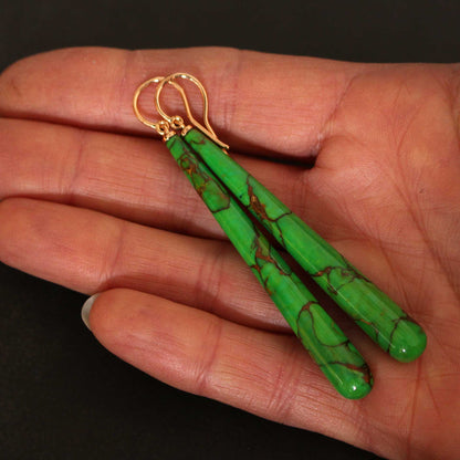 Größenvergleich der 60mm langen iranischen Türkis-Pampeln in der Handfläche. Die Aufnahme zeigt die natürliche Oberflächenstruktur der Edelsteine und die feine handwerkliche Verarbeitung der Goldschmiedin.